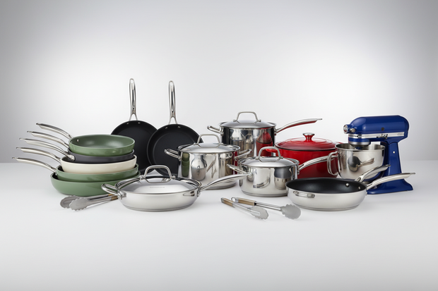 Collection of cookware including pots, pans, and a mixer on a white background